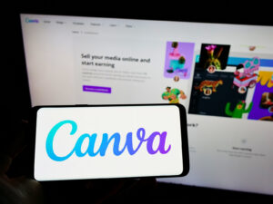 Canva na smartfonie na tle strony platformy – rozwój AI i marketing automation