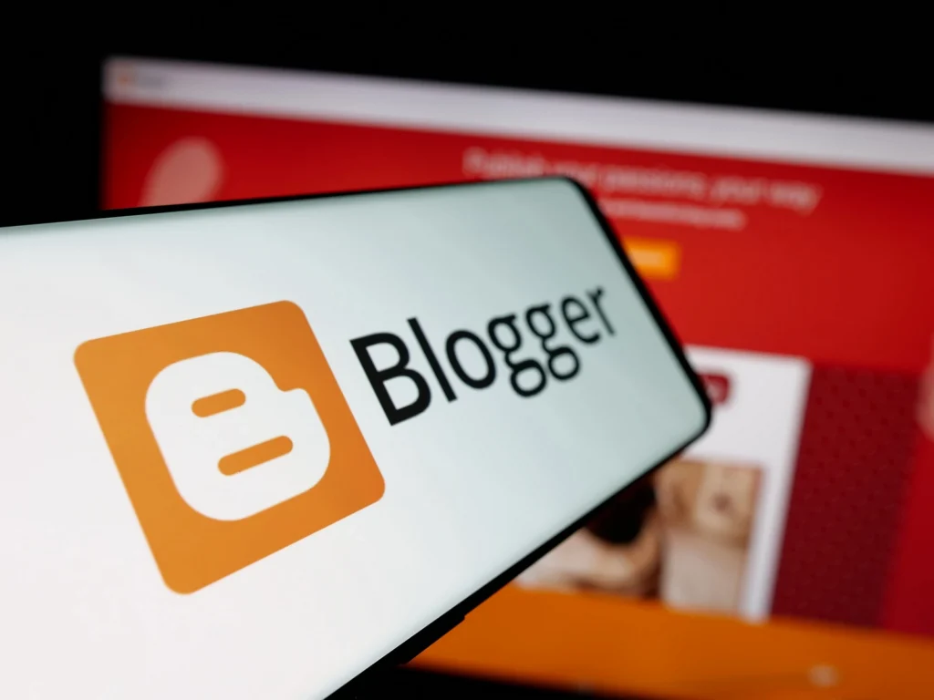 Logo Bloggera na ekranie smartfona na tle strony Blogspot