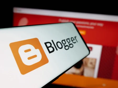 Logo Bloggera na ekranie smartfona na tle strony Blogspot