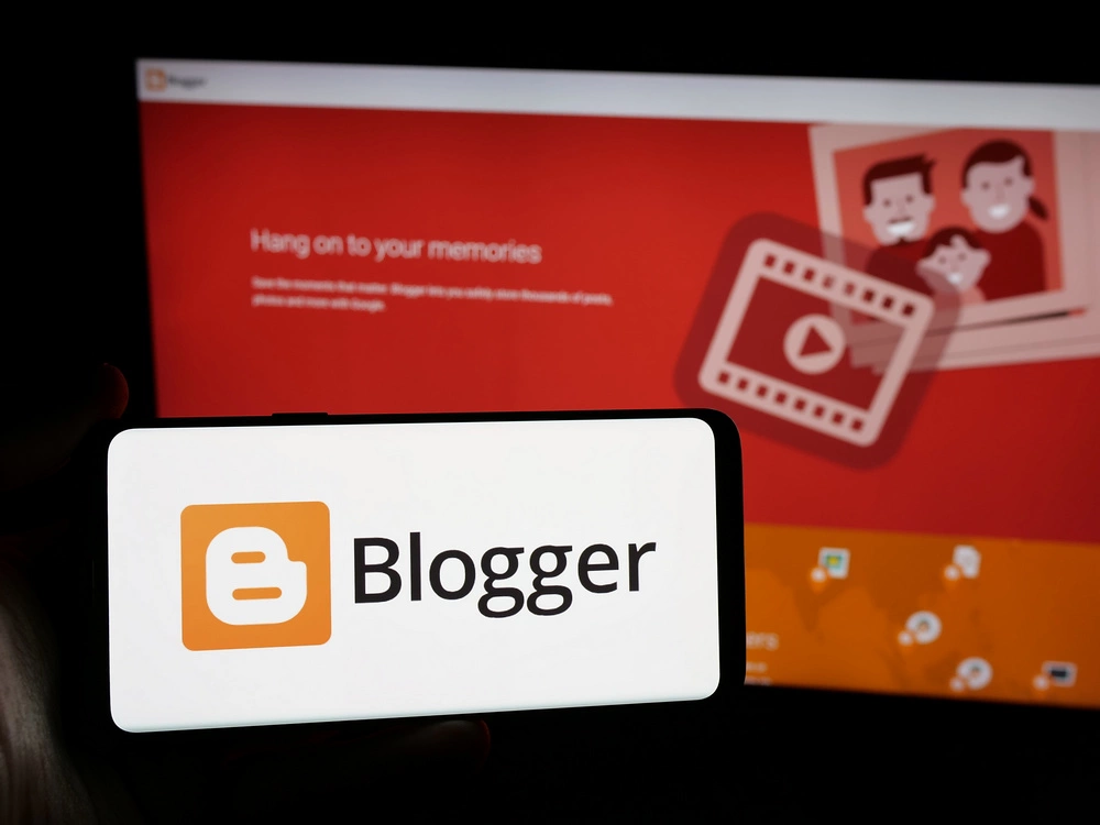 Logo Bloggera, znanego jako Blogspot, na ekranie smartfona na tle strony Bloggera