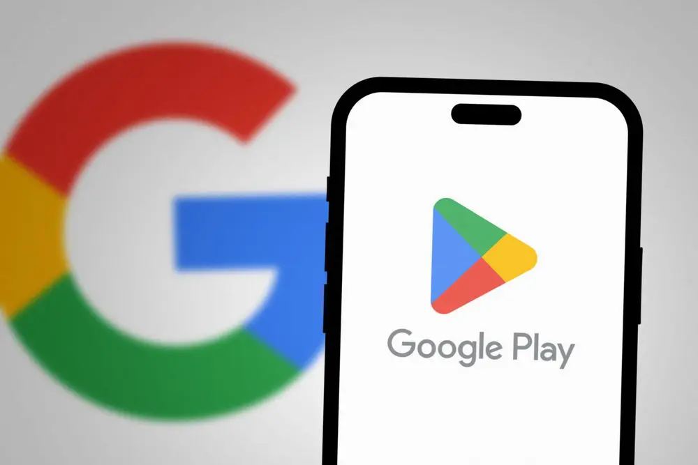 Google Play na ekranie smartfona z logo Google w tle