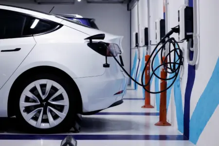 Samochód elektryczny podłączony do ładowarki.